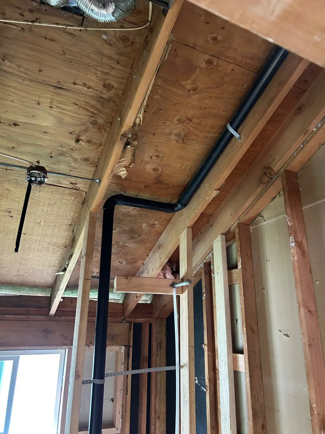 ABS drain and vent stack routed through ceiling joists during a remodel by Wild Pine Plumbing in St Helens, Oregon
