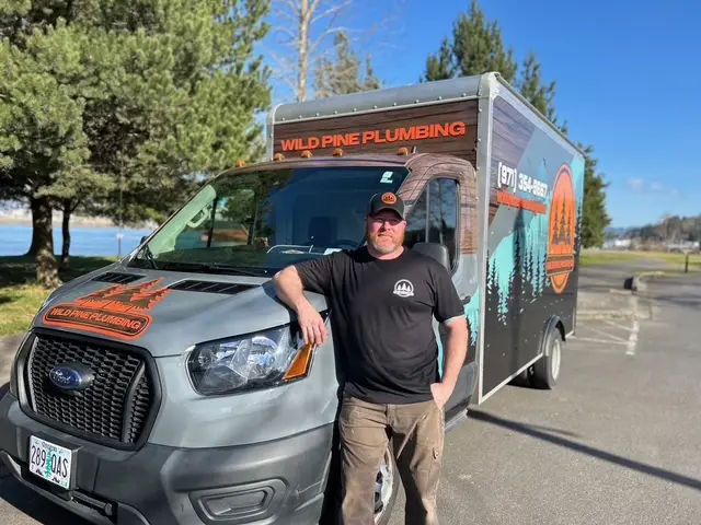 Wild Pine Plumbing owner in front of the branded Ford Transit box truck in St Helens, Oregon