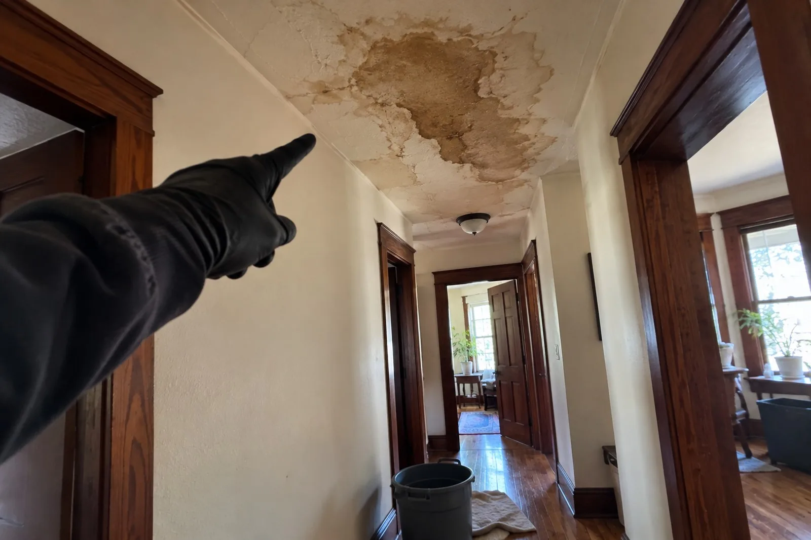 Technician pointing to a water stain on the hallway ceiling of an older Portland home